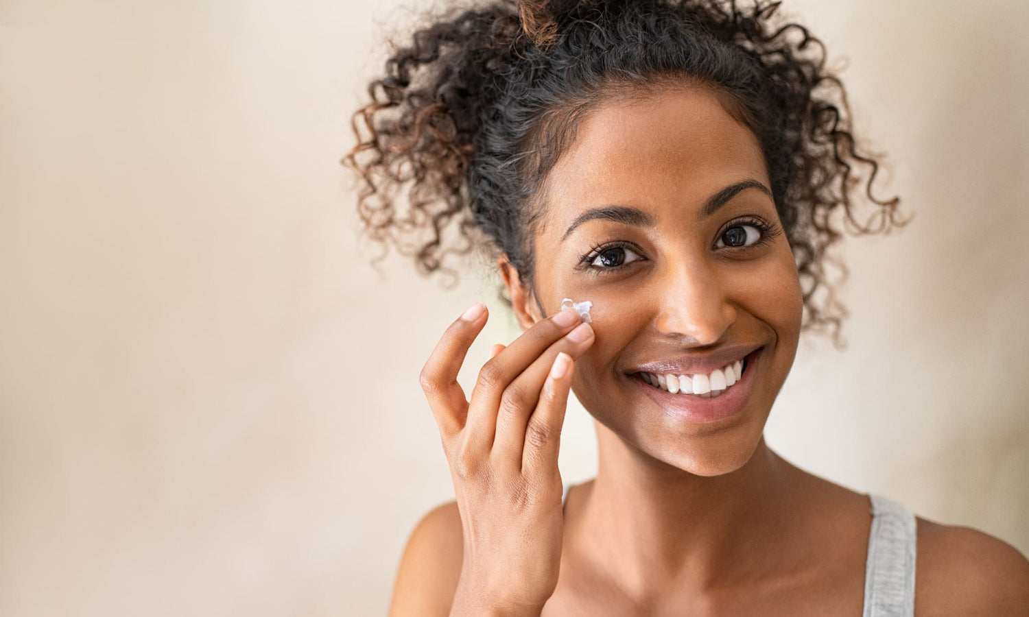 cute young girl putting face cream on her face