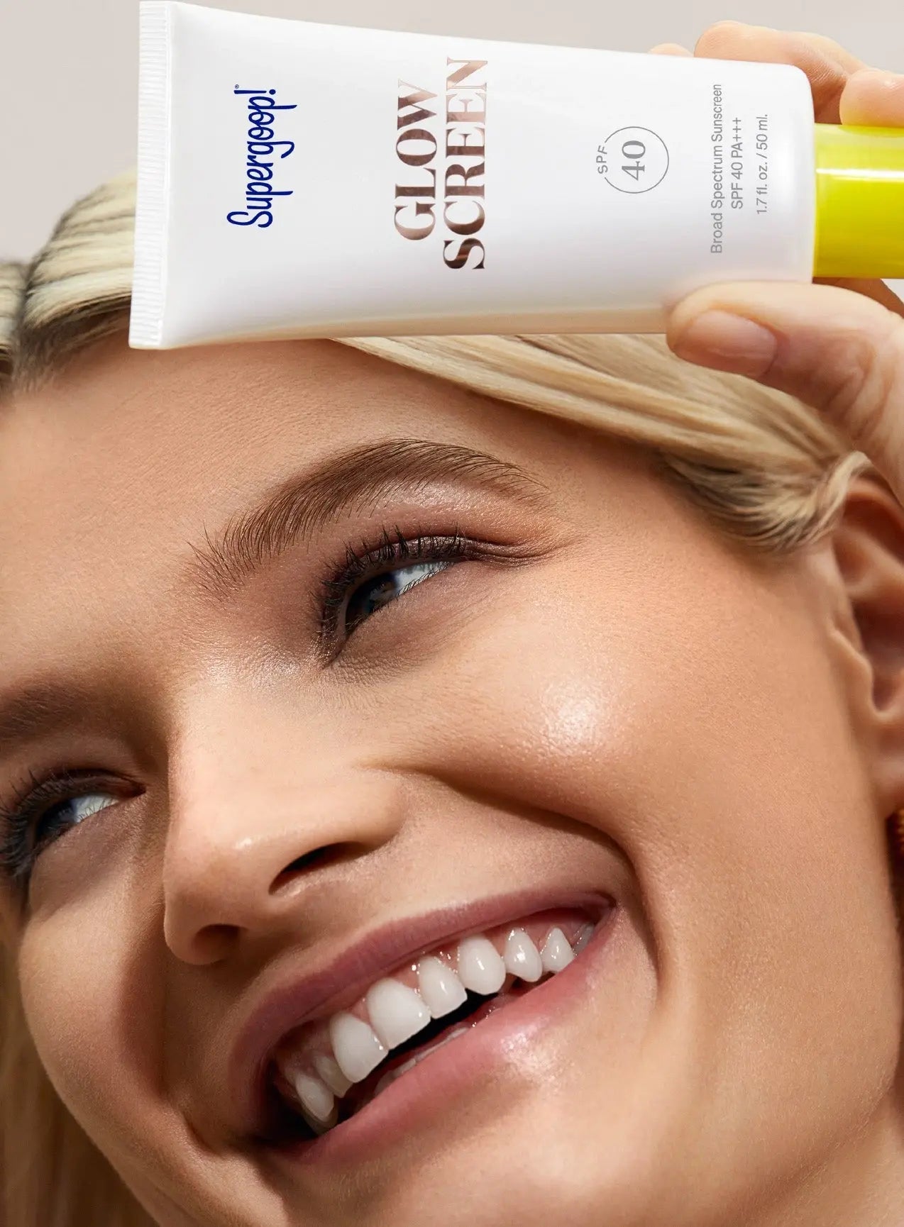 girl holding bottle of Supergoop Glow Screen SPF 40