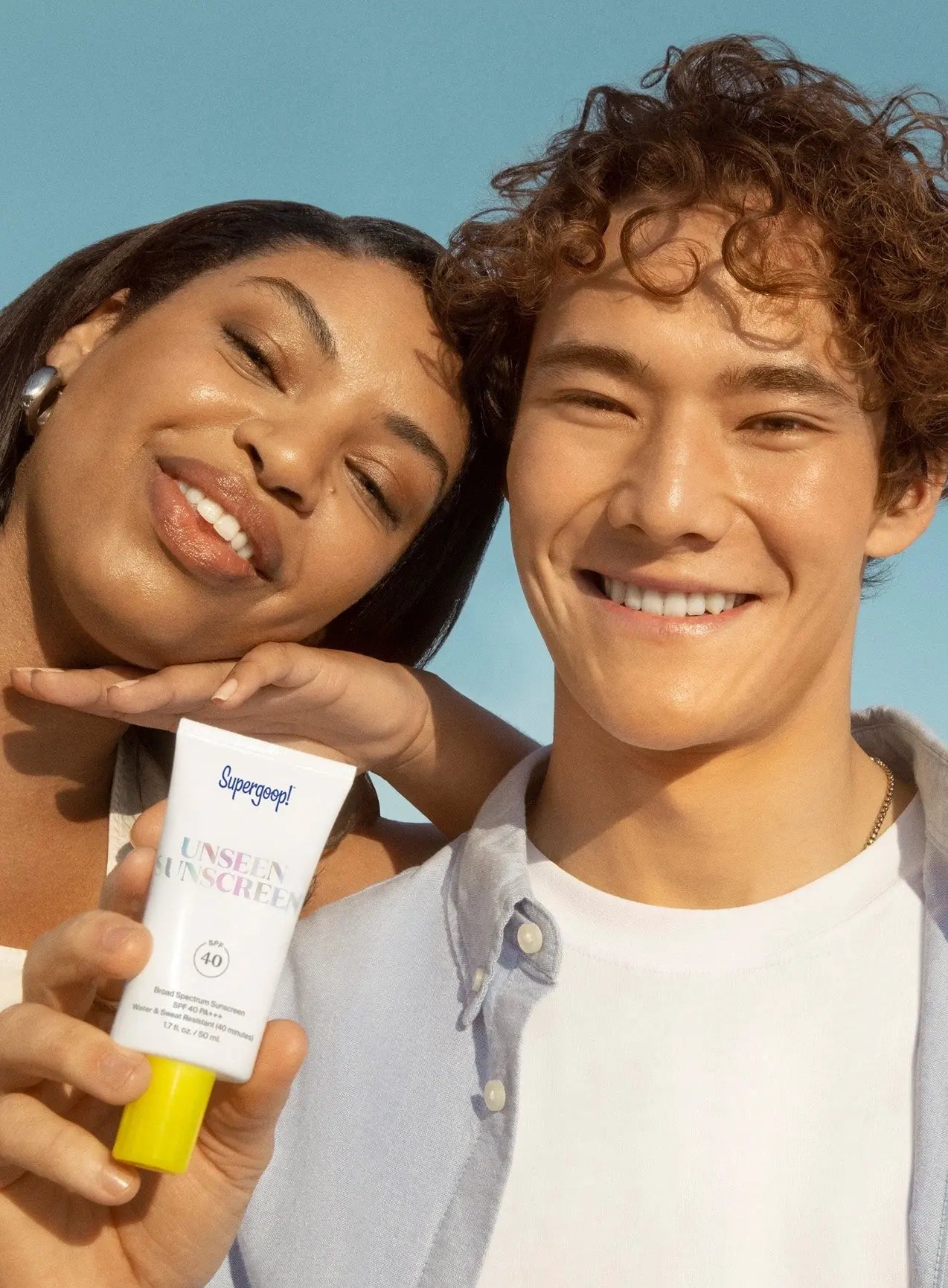 boy and girl holding a Supergoop Unseen Sunscreen SPF 40
