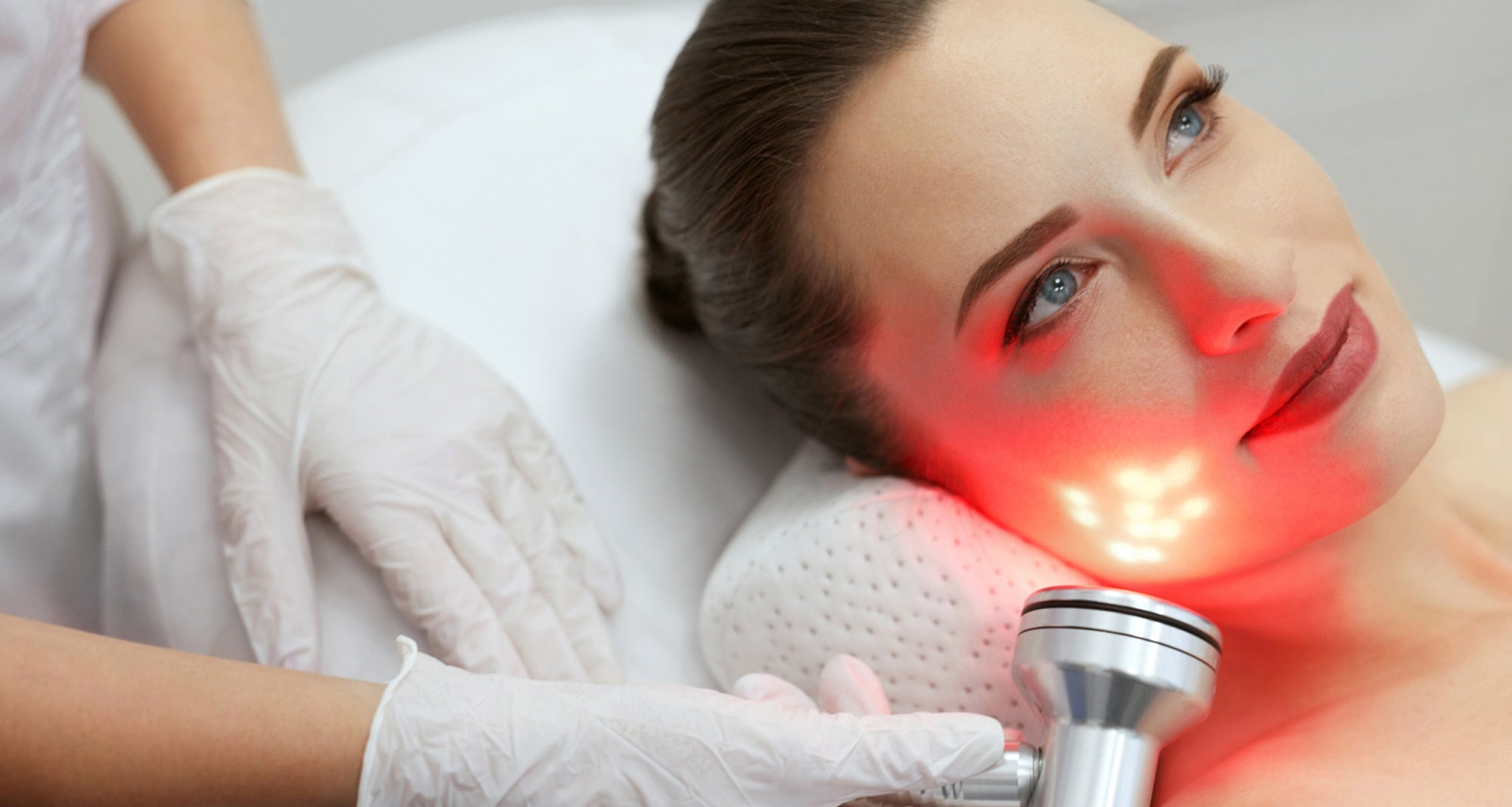 woman getting infrared light treatment done on her face