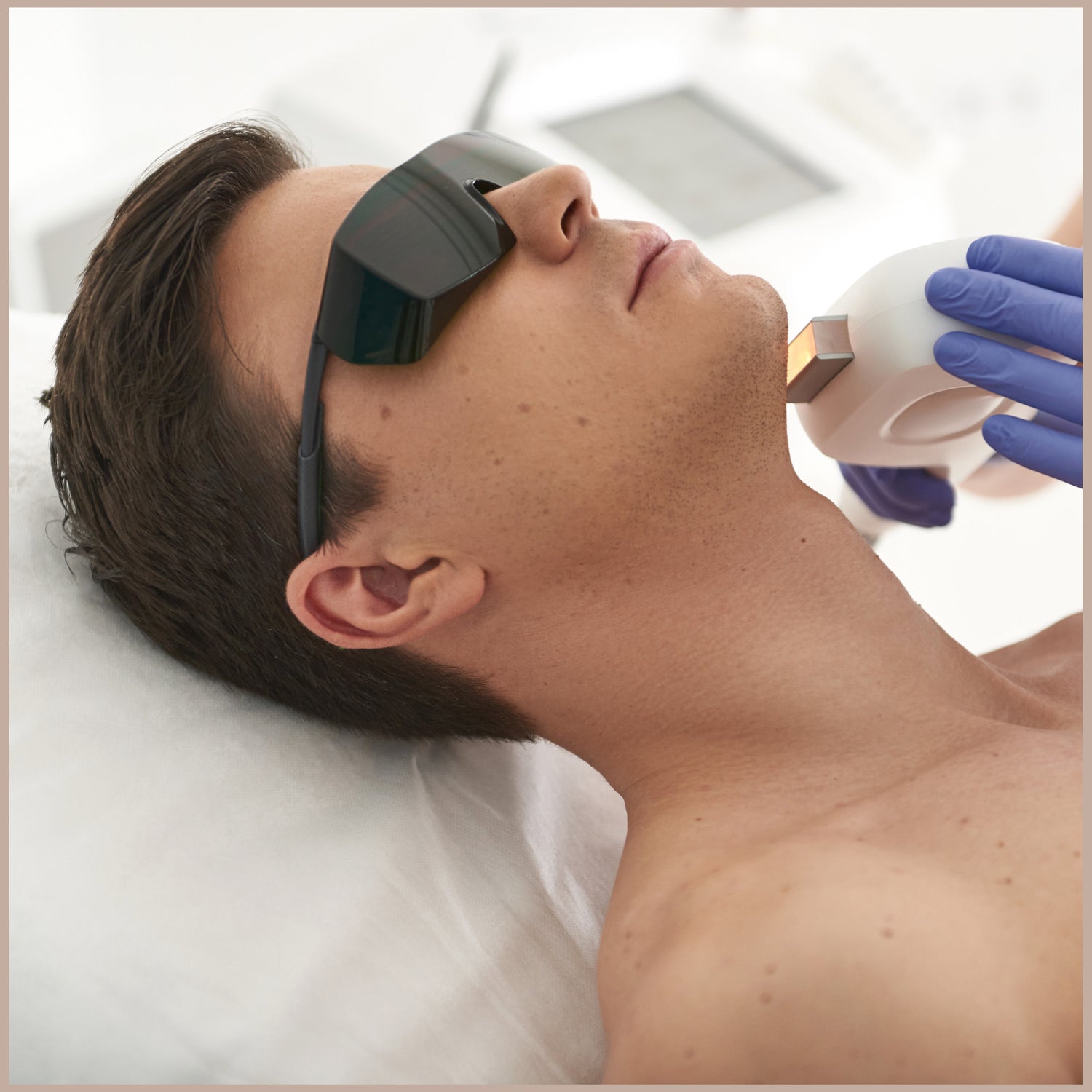 man wearing protective glasses getting laser removal on his chin
