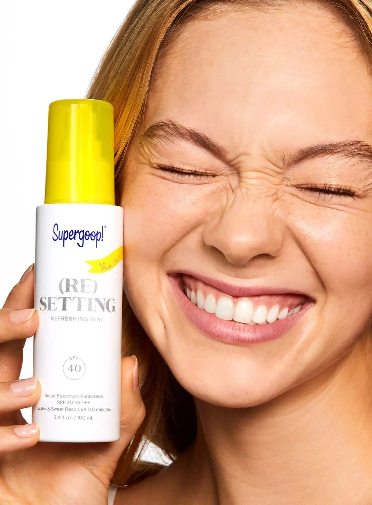 (Re)Setting Refreshing Mist SPF 40 being held by a woman squinting her eyes